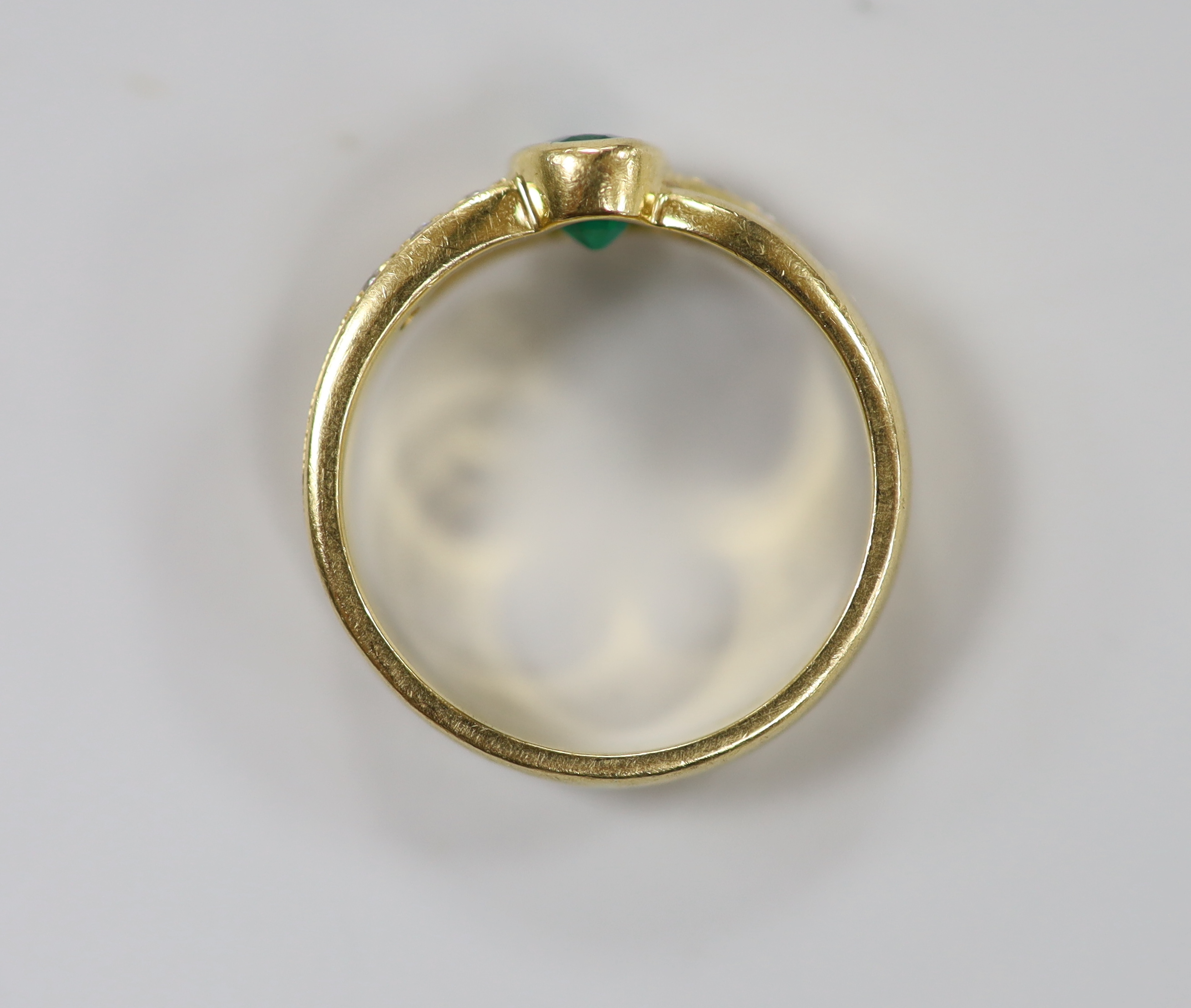 A modern 18ct gold and single stone oval cut emerald ring, with six stone diamond set shoulders, size J. gross weight 4.7 grams.